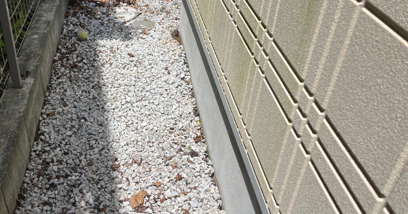 草取り後の同じ建物脇。砂利の通路が見える状態